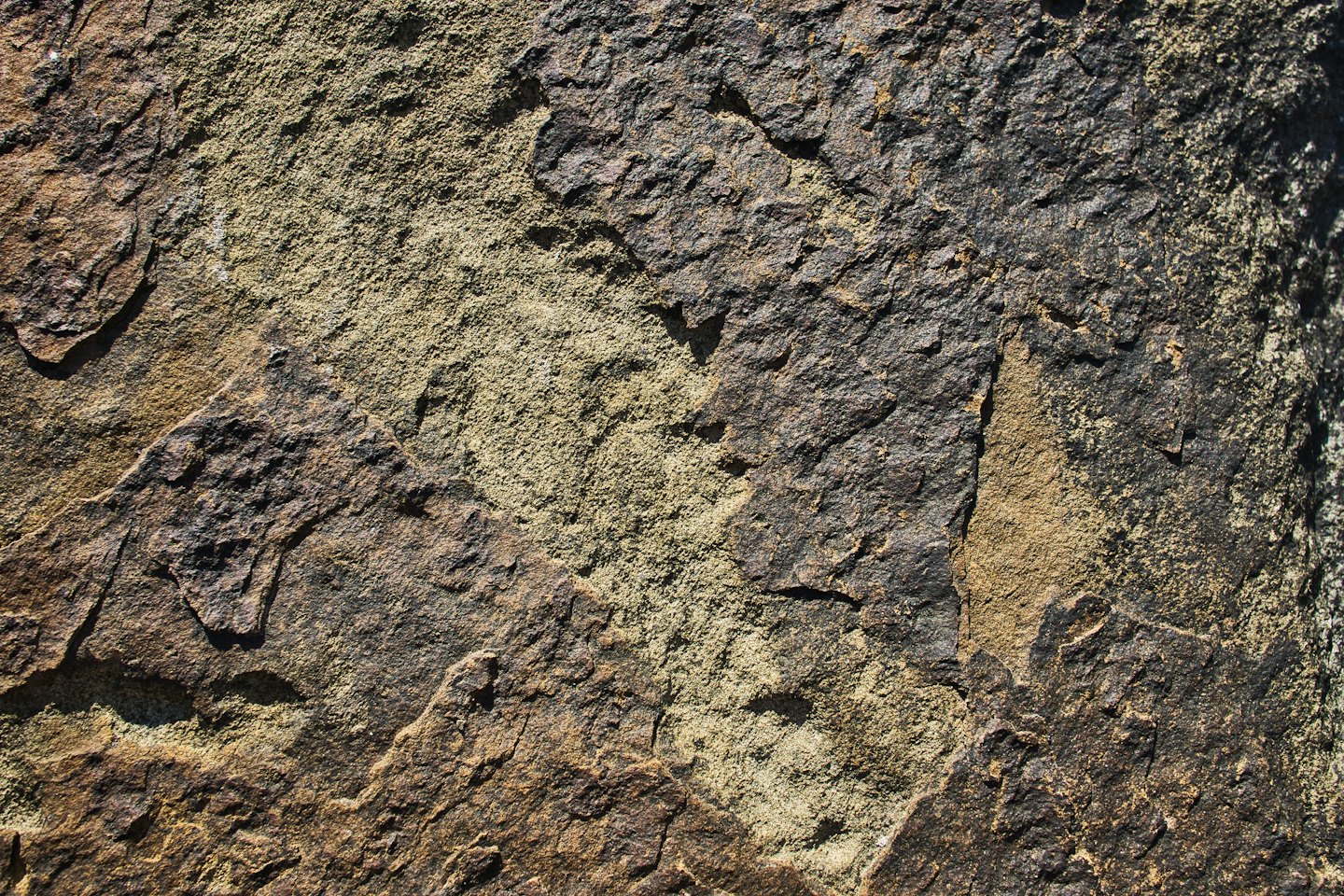 Rugged natural stone surface with brown and grey mottled texture.